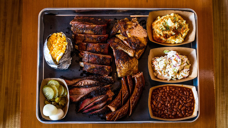 Large BBQ tray with ribs, brisket, sausage and chicken along with sides.
