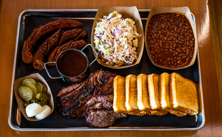 Large BBQ tray with ribs, brisket, sausage and chicken along with sides.
